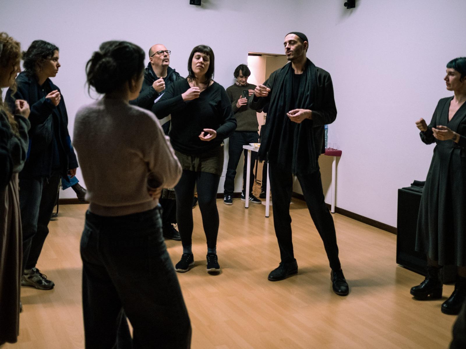 A photo from the opening of the Center, where people are singing in a guided improvisation lead by Giulia Matteucci